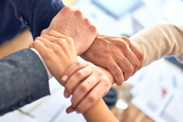 team members gripping wrists in unity gesture